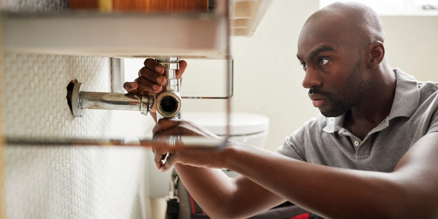 a male plumber fixing a pipe connection from Quality Plumber Leander in Leander, TX Plumber near me